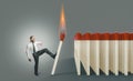 Businessman kicking a lit match to ignite a chain reaction Royalty Free Stock Photo