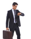 This businessman knows how important time is. A handsome young businessman holding a briefcase and checking his watching Royalty Free Stock Photo