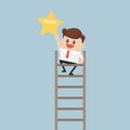 Businessman on a ladder grab star.