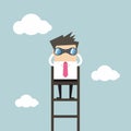 Businessman on a ladder using binoculars above cloud Royalty Free Stock Photo