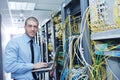 Businessman with laptop in network server room Royalty Free Stock Photo