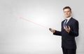 Businessman with laser pointer and copyspace white wall