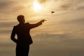 A businessman launches a paper airplane into the sky