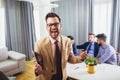 Businessman leader looking at camera in modern office with businesspeople working at the background. Royalty Free Stock Photo