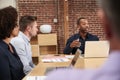 Businessman Leading Office Meeting Around Table