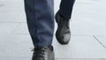 Businessman legs walking on city street.Entrepreneur wearing black leather shoes Royalty Free Stock Photo