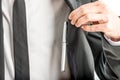Businessman lifting aside his jacket to access a pen Royalty Free Stock Photo