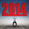Businessman lifting new year 2014 under blue sky Royalty Free Stock Photo