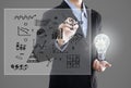 Businessman with lightbulb and hand drawing graph inspiration .