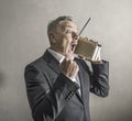 Businessman listening to the radio making strange expressions