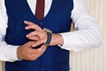 Businessman look his watch, a man in a blue suit and burgundy tie checks the time Royalty Free Stock Photo