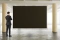 Businessman looking at blank blackboard in sunny spacious hangar Royalty Free Stock Photo