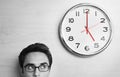 Businessman Looking At Clock On Wooden Wall Royalty Free Stock Photo