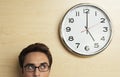 Businessman Looking At Clock On Wooden Wall Royalty Free Stock Photo