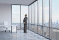 Businessman is looking through the corner window. New York background.