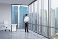 Businessman is looking through the corner window. Singapore background.