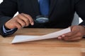 Businessman looking at document through magnifying glass Royalty Free Stock Photo