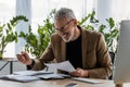 Businessman looking at document near smartphone with blank screen in office Royalty Free Stock Photo