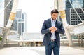 The businessman looking down at his watch and wearing deep blue suit while he waiting his friend at the outside office Royalty Free Stock Photo