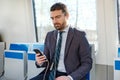 Businessman is looking at his mobile phone while is going to wor Royalty Free Stock Photo