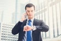 Businessman looking at his watch checking time while calling on Royalty Free Stock Photo