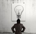 Businessman looking at light bulb in art frame Royalty Free Stock Photo