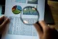 Businessman looking through a magnifying glass to documents. Business assessment and audit. Magnifying glass on a financial report Royalty Free Stock Photo