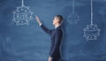 Businessman looking at the naval mines and the word `risk``drawn with chalk on the dark blue wall.