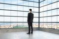 Businessman looking out the window of empty loft room Royalty Free Stock Photo