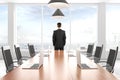 Businessman looking out the window in modern conference room wit Royalty Free Stock Photo