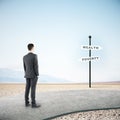 Businessman looking on poverty and wealth sign post Royalty Free Stock Photo