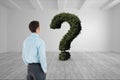 Businessman looking at question mark made of plants Royalty Free Stock Photo