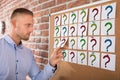 Businessman Looking At Question Marks On Notes