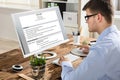 Businessman Looking At Resume On Computer