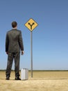 Businessman Looking At Road Sign On Desert Royalty Free Stock Photo