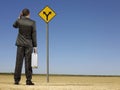 Businessman Looking At Road Sign On Desert Royalty Free Stock Photo