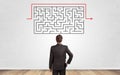 Businessman looking to a maze on a wall Royalty Free Stock Photo