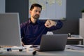 Businessman  Looking At Watch While Working Late Royalty Free Stock Photo