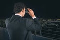 Businessman looks at the city with binoculars during night. Future and new business opportunity concept