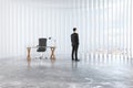 Businessman looks out the window in empty loft room with glassy Royalty Free Stock Photo