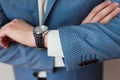 Businessman looks the time on his wristwatch