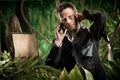 Businessman lost in jungle calling for help Royalty Free Stock Photo