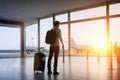 Businessman with luggage at airport departure gate. Waiting for flight. businessman standing at the airport window at Airport Royalty Free Stock Photo