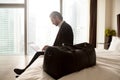 Businessman with luggage works on laptop at hotel