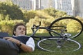 Businessman Lying Down On Bicycle In Park Royalty Free Stock Photo