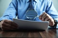 Businessman with magnifying glass reading documents Royalty Free Stock Photo