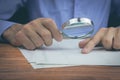 ..Businessman with magnifying glass reading documents Royalty Free Stock Photo