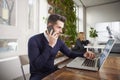 Businessman with making a call and working on laptop while sitting in the office Royalty Free Stock Photo
