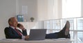 Businessman making phone call sitting with legs on table in office Royalty Free Stock Photo