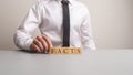 Businessman making a sign Facts with wooden cubes